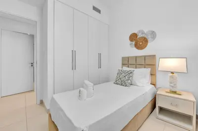 a white bedroom with two beds and a lamp at Modern 2BR at Burj Crown Walk to Burj Khalifa by Vibel Stay in Dubai