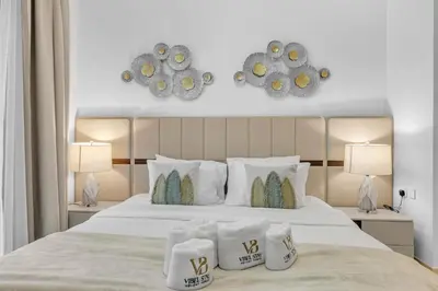 a bedroom with a large white bed with two lamps at Modern 2BR at Burj Crown Walk to Burj Khalifa by Vibel Stay in Dubai