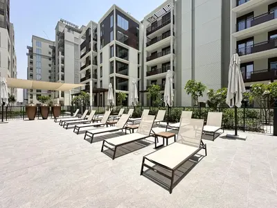 a row of chairs and umbrellas in a courtyard at Chic Dubai Apartment Creek View Peaceful Vibes in Dubai