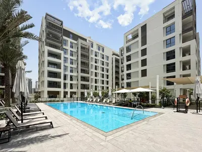a swimming pool with chairs and a building at Chic Dubai Apartment Creek View Peaceful Vibes in Dubai