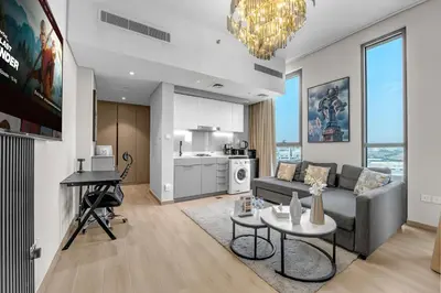 a living room with a couch and a table at Peaceful Studio Midtown 20 mins to Expo City by Vibel in Dubai