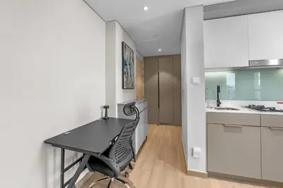 a kitchen with a black table and a black chair at Peaceful Studio Midtown 20 mins to Expo City by Vibel in Dubai