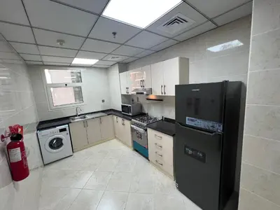 a kitchen with a black refrigerator and a dishwasher at Wonderful Rental Apartments in Dubai Silicon Oasis in Dubai