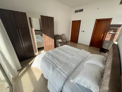 a bedroom with a large white bed in a room at Wonderful Rental Apartments in Dubai Silicon Oasis in Dubai