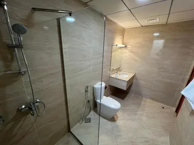 a bathroom with a shower with a toilet and a sink at Wonderful Rental Apartments in Dubai Silicon Oasis in Dubai