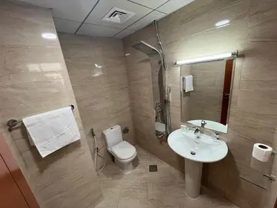 a bathroom with a toilet and a sink at Wonderful Rental Apartments in Dubai Silicon Oasis in Dubai