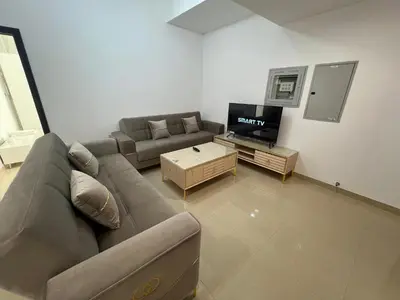 a living room with a couch and a tv at Wonderful Rental Apartments in Dubai Silicon Oasis in Dubai