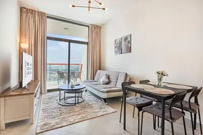 a living room with a table and a couch at One Bedroom Apartment in Binghatti Avenue by The S Holiday Homes in Dubai