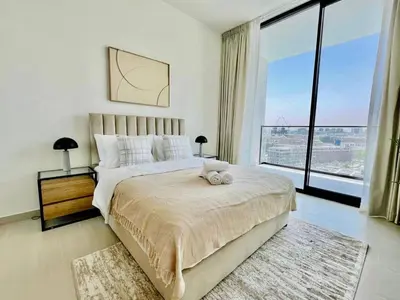 a bedroom with a large bed and a large window at Cozy 1br In Jvc Pool, Balcony & Free Parking in Dubai