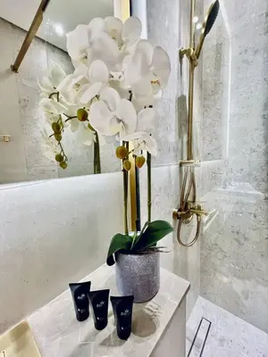 a vase with white flowers sitting on a counter at Cozy 1br In Jvc Pool, Balcony & Free Parking in Dubai