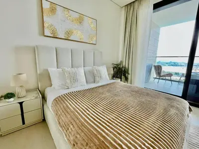 a bedroom with a large bed with a large window at Canal-view Studio Jacuzzi Business Bay in Dubai