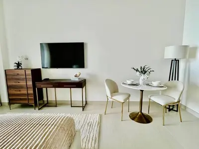 a bedroom with a bed and a table and a tv at Canal-view Studio Jacuzzi Business Bay in Dubai
