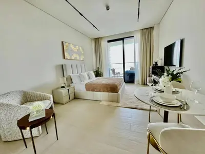 a large living room with a bed and a table at Canal-view Studio Jacuzzi Business Bay in Dubai