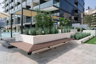 a bench in front of a building with plants at Canal-view Studio Jacuzzi Business Bay in Dubai