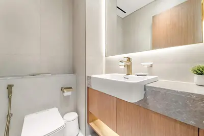 a bathroom with a sink and a toilet and a mirror at Silkhaus New 1BDR Retreat at Binghatti Tulip in JVC in Dubai