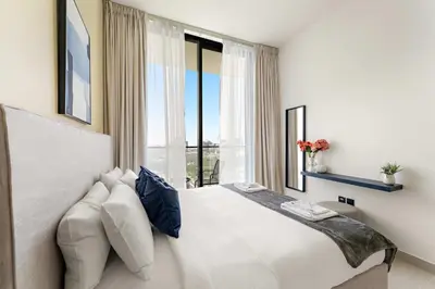 a bedroom with a large white bed with a window at Silkhaus New 1BDR Retreat at Binghatti Tulip in JVC in Dubai