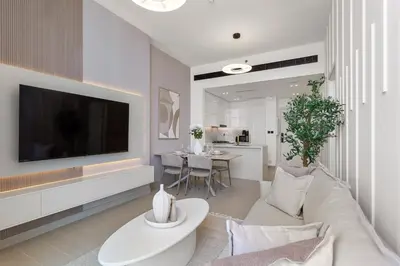 a living room with a white couch and a tv at Elegant 1 Bedroom in Binghatti Tulip - JVC in Dubai