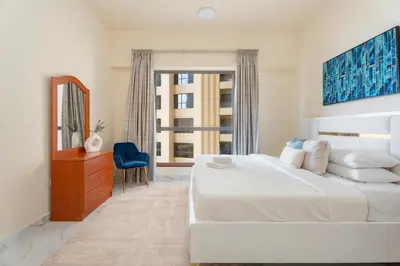 a bedroom with a large white bed and a window at GuestReady - Premium stay in JBR walk in Dubai