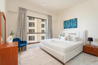 a bedroom with a large white bed and a window at GuestReady - Premium stay in JBR walk in Dubai