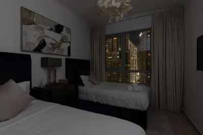a hotel room with two beds and a window at Burj and Fountain view 3BR plus maids room in Dubai