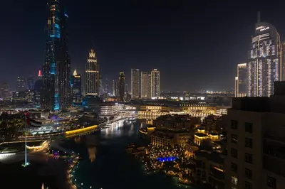 a city skyline at night with a river and buildings at Burj and Fountain view 3BR plus maids room in Dubai