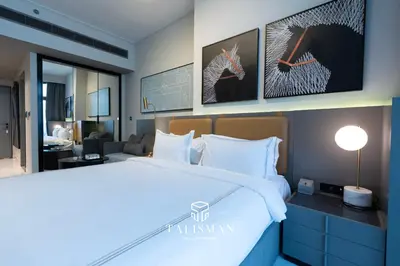 a hotel room with a large bed and a desk at Canal View Studio MAG 318 in Dubai
