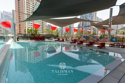 a swimming pool with tables and chairs in a building at Canal View Studio MAG 318 in Dubai