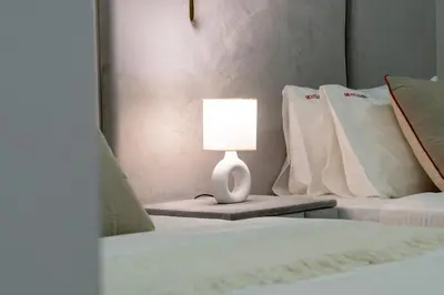 a lamp sitting on a table next to two beds at 3BR Apartment in the heart of Dubai Marina in Dubai
