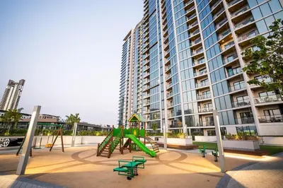 a playground in front of a large apartment building at Sobha Waves Grande Big 1BR apt Burj Khalifa views! in Dubai
