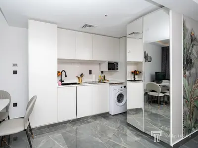 a kitchen with white cabinets and a washing machine at Cozy and Uniquely Furnished One Bedroom Dubai Marina in Dubai