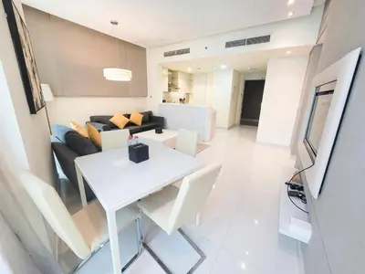 a living room with a white table and a couch at Damac Voleo - Blue Ocean Holiday Homes in Dubai