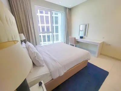 a bedroom with a bed and a large window at Damac Voleo - Blue Ocean Holiday Homes in Dubai