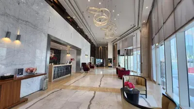 a lobby of a building with a chandelier at Damac Voleo - Blue Ocean Holiday Homes in Dubai