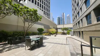a courtyard in a building with a table and chairs at Damac Voleo - Blue Ocean Holiday Homes in Dubai