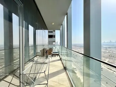 a glass balcony with chairs on a building at Homes2Retreat - Luxury Finishes with Full Skyline View in Dubai