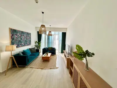 a living room with a blue couch and a table at Homes2Retreat - Luxury Finishes with Full Skyline View in Dubai