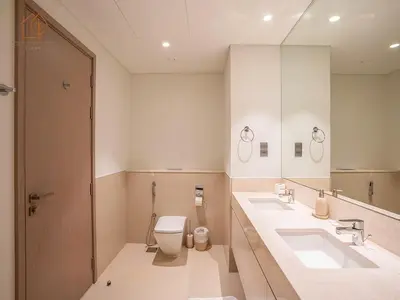 a bathroom with two sinks and a toilet and a mirror at Burj Views Elegance from 3 Bedroom Apartment 214-A1-3 in Dubai