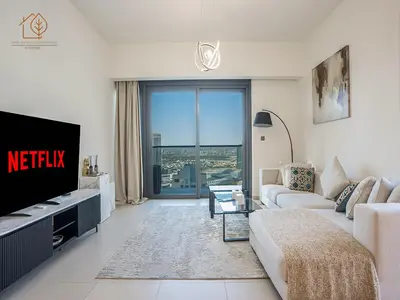 a living room with a couch and a tv at Burj Views Elegance from 3 Bedroom Apartment 214-A1-3 in Dubai