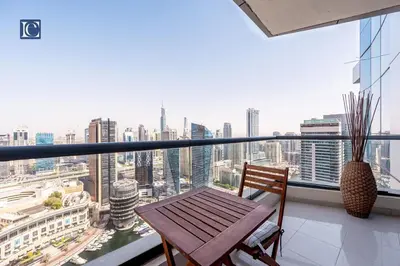 a balcony with a wooden table and a view of a city at Luxury Escapes- Elegant Marina View Bay Central 3BR and Maids Room- single bed in Dubai