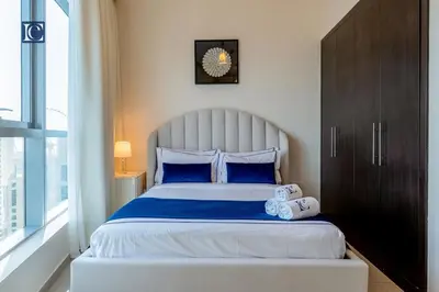 a bedroom with a large bed with blue pillows at Luxury Escapes- Elegant Marina View Bay Central 3BR and Maids Room- single bed in Dubai