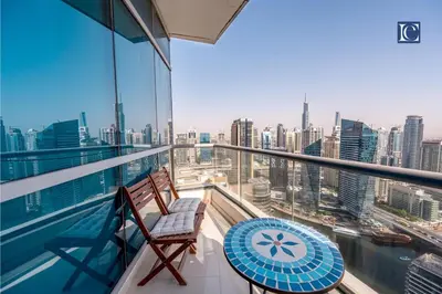 a balcony with a table and chairs and a view of the city at Luxury Escapes- Elegant Marina View Bay Central 3BR and Maids Room- single bed in Dubai