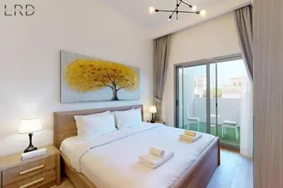 a bedroom with a bed with two towels on it at Brand New and Modern Studio Apartment in Dubai