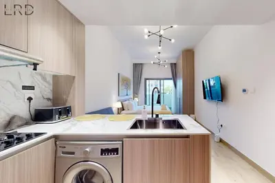 a kitchen with a sink and a washing machine at Brand New and Modern Studio Apartment in Dubai