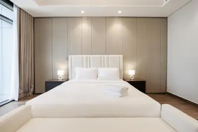 a bedroom with a large white bed with two lamps at Centrally Located 1BR in Business Bay Near Canal and Downtown in Dubai