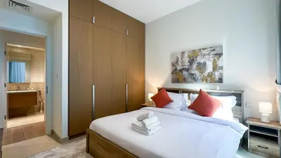 a bedroom with a large white bed with red pillows at Resort-Style 1BR in Dubai Creek Harbour -1AB01 in Dubai