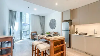 a kitchen with a table with chairs and a refrigerator at Resort-Style 1BR in Dubai Creek Harbour -1AB01 in Dubai
