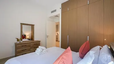 a bedroom with a bed and a dresser and a mirror at Resort-Style 1BR in Dubai Creek Harbour -1AB01 in Dubai