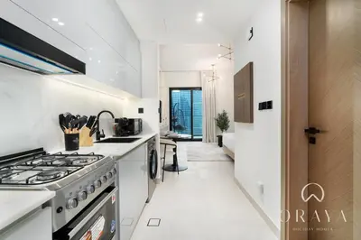 a kitchen with white counters and a stove top oven at Studio With Jaw-Dropping Canal And Burj Views in Dubai