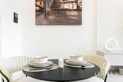 a black dining room table with two chairs and a painting at Studio With Jaw-Dropping Canal And Burj Views in Dubai