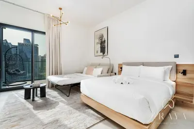 a bedroom with a large white bed and a couch at Studio With Jaw-Dropping Canal And Burj Views in Dubai